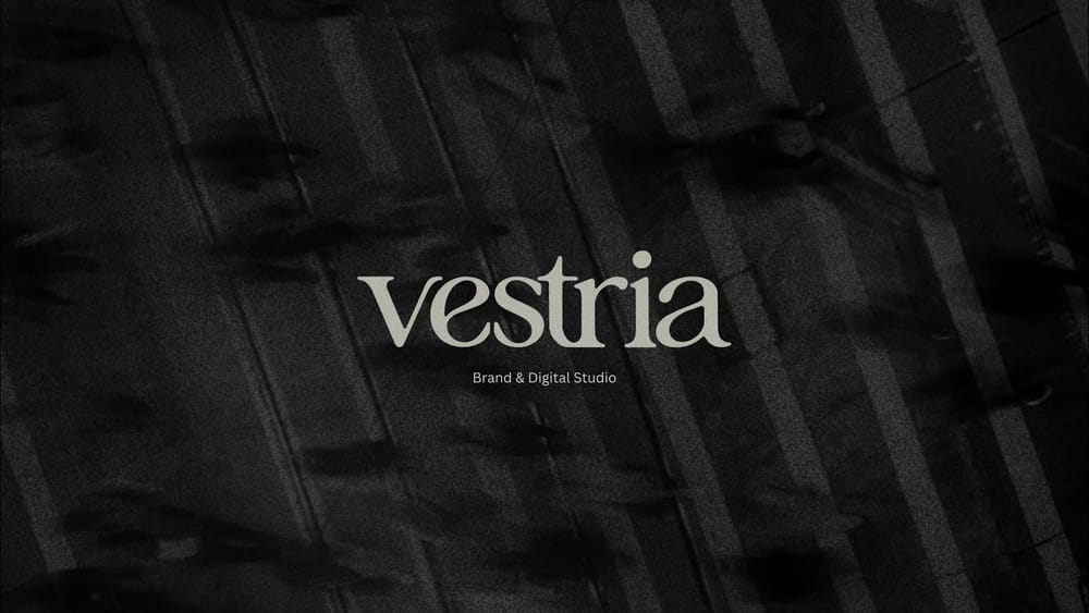 Logotipo de Vestria, Brand & Digital Studio, en gris claro sobre una textura negra